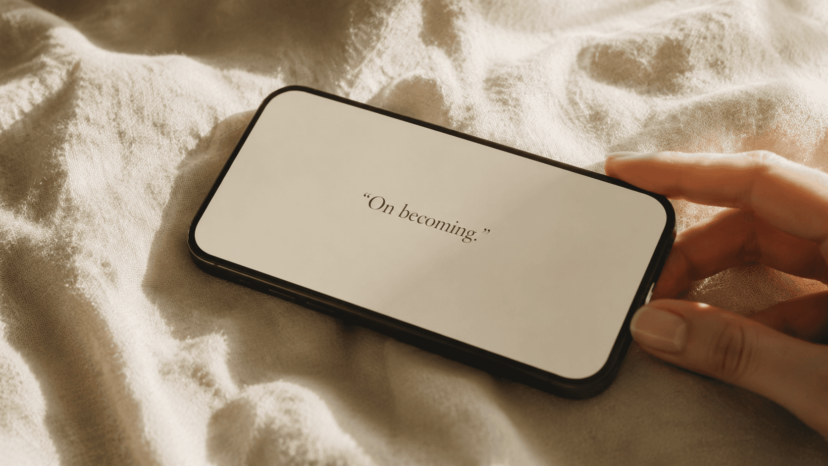 Editorial phone mockup showing the quote 'On becoming.' on cream linen.