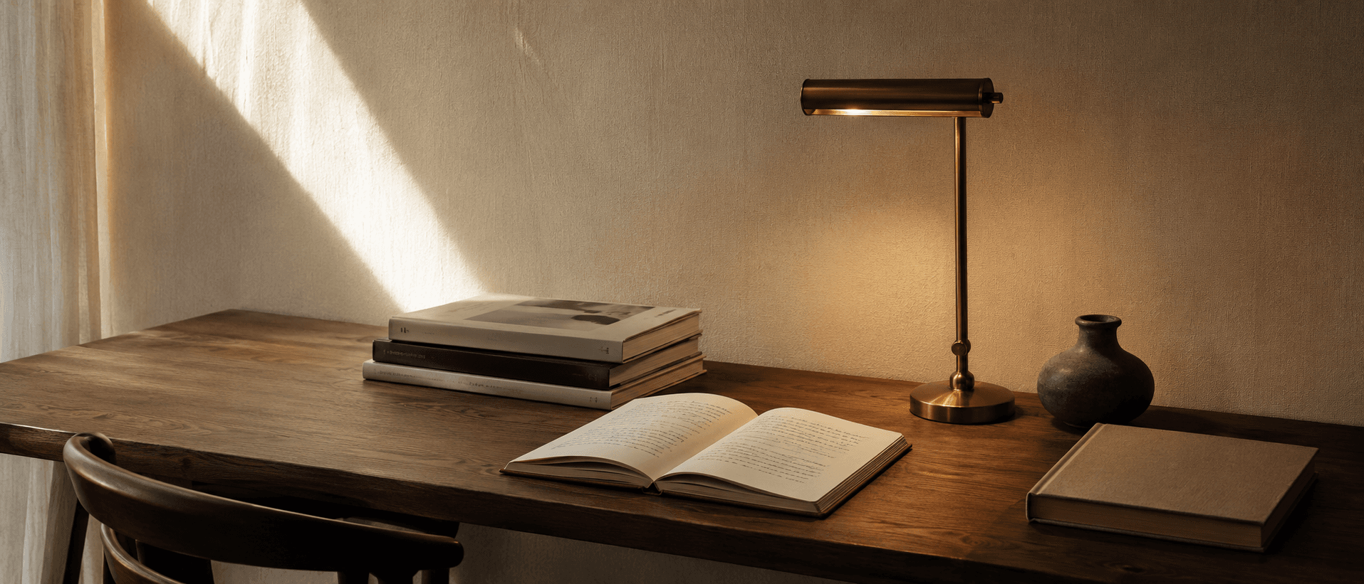 Inside the studio — warm cinematic desk with brass lamp.